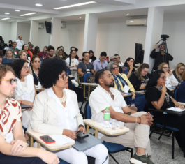 Fotografia de cerca de 80 participantes da formação do CREPOP sentados em carteiras em um auditório. No primeiro plano, da esquerda para a direita, estão sentados o conselheiro do CFP Leandro Amorim Rosa, a conselheira do CFP Miriam Alves e o supervisor do CREPOP Bruno Correia da Mota.